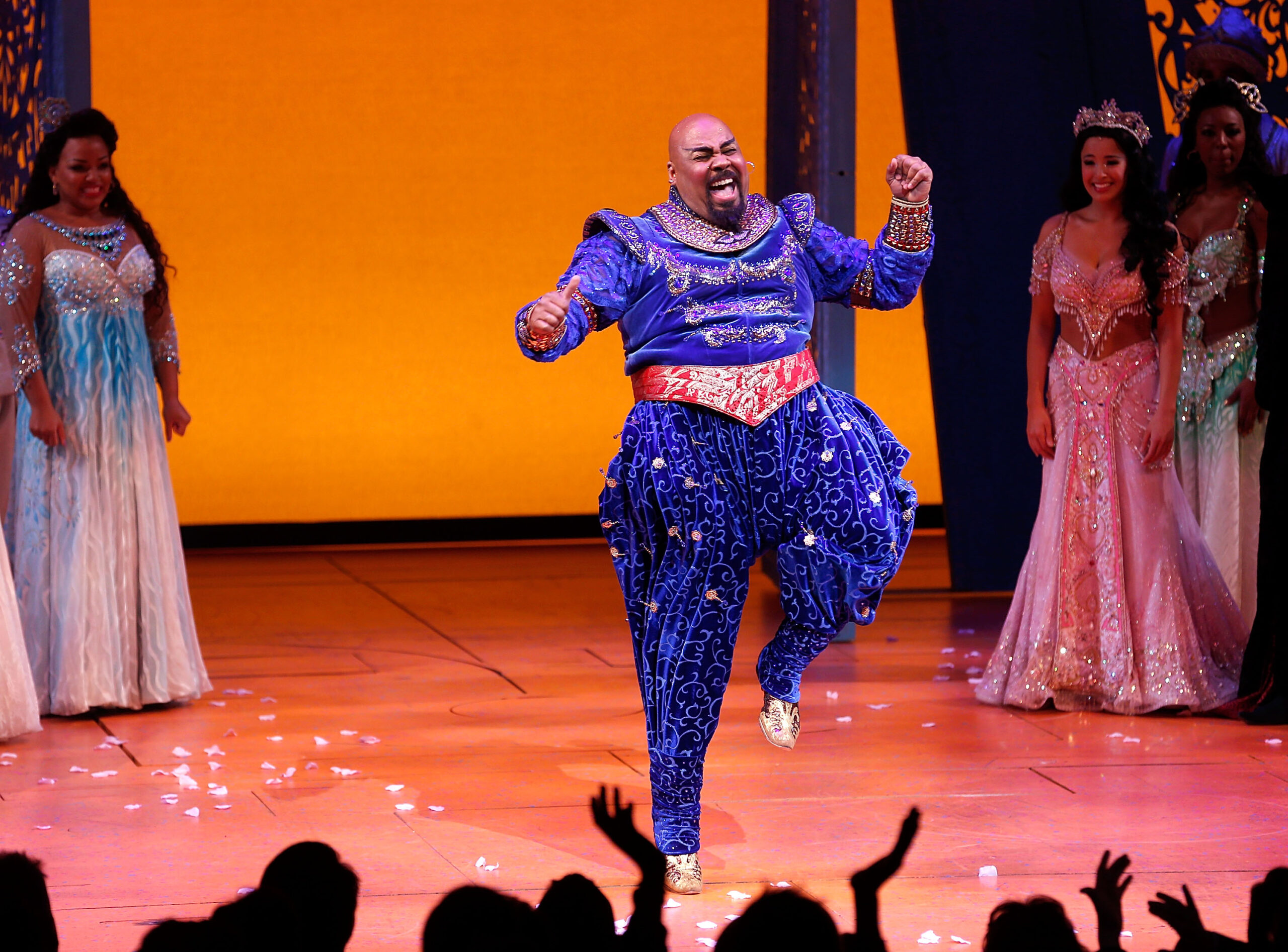 Een man zingt en springt op het podium als Aladdin.