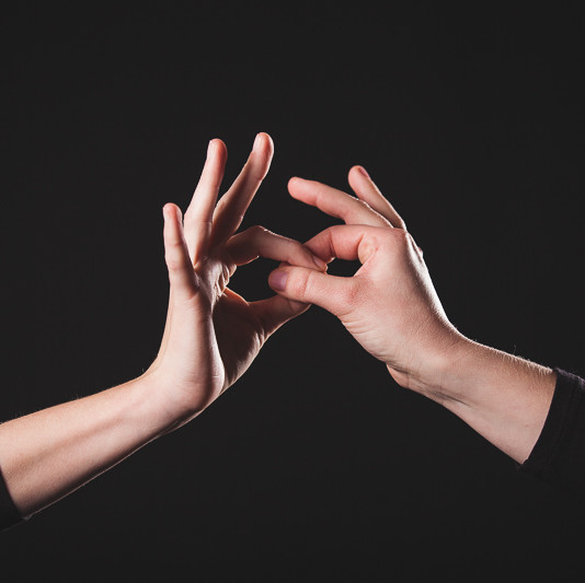 2 mensen raken elkaars duim en wijsvinger aan.