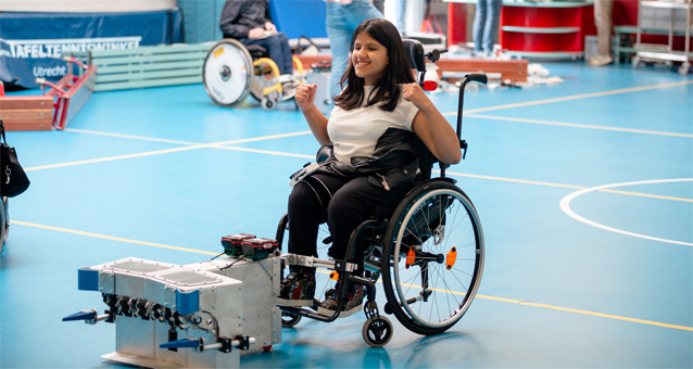 Er is een meisje in een rolstoel in een gymzaal aan het sporten.