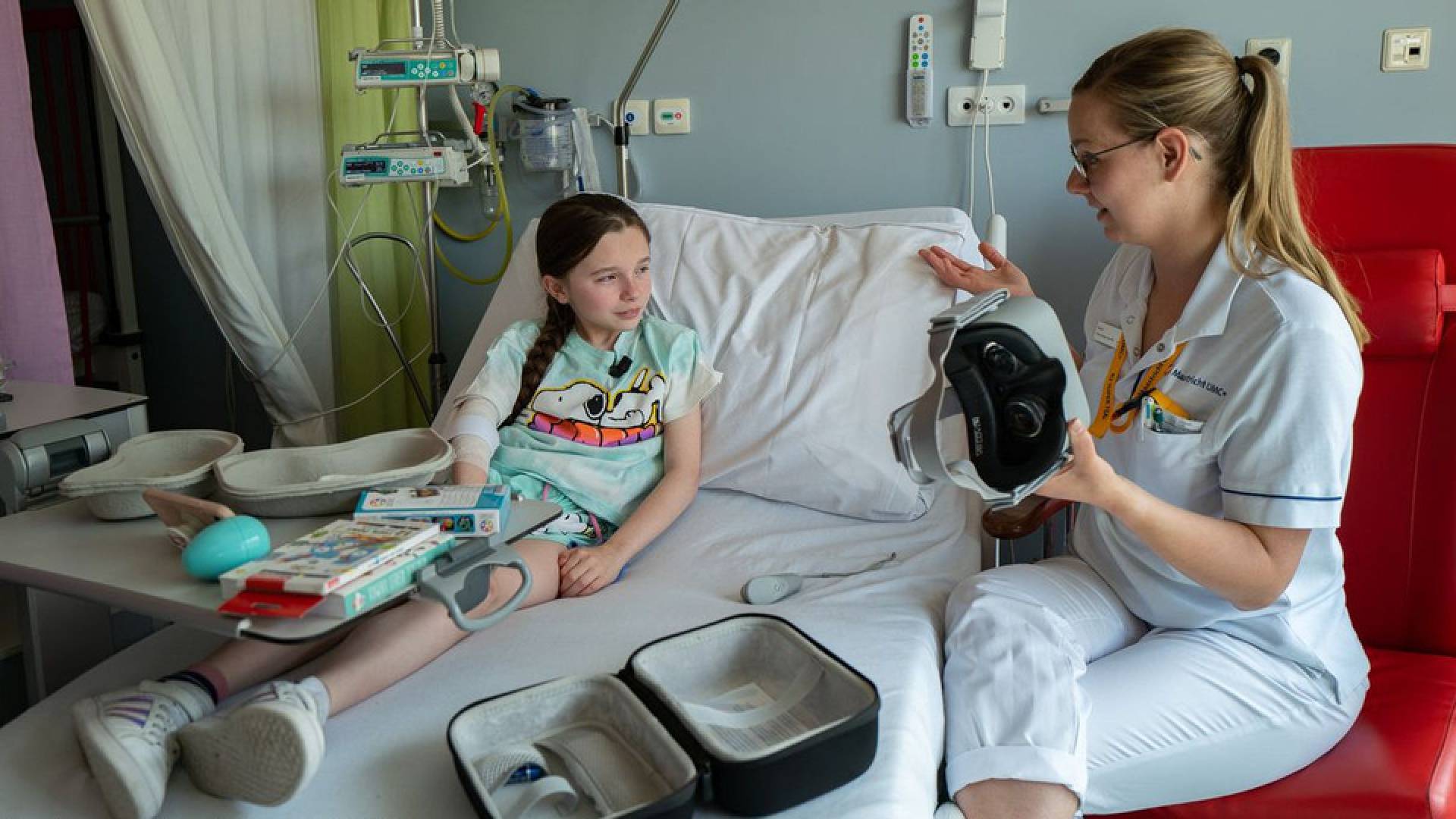 Een kindje ligt in een ziekenhuis bed en een verpleegster heeft een VR Bril in haar hand.